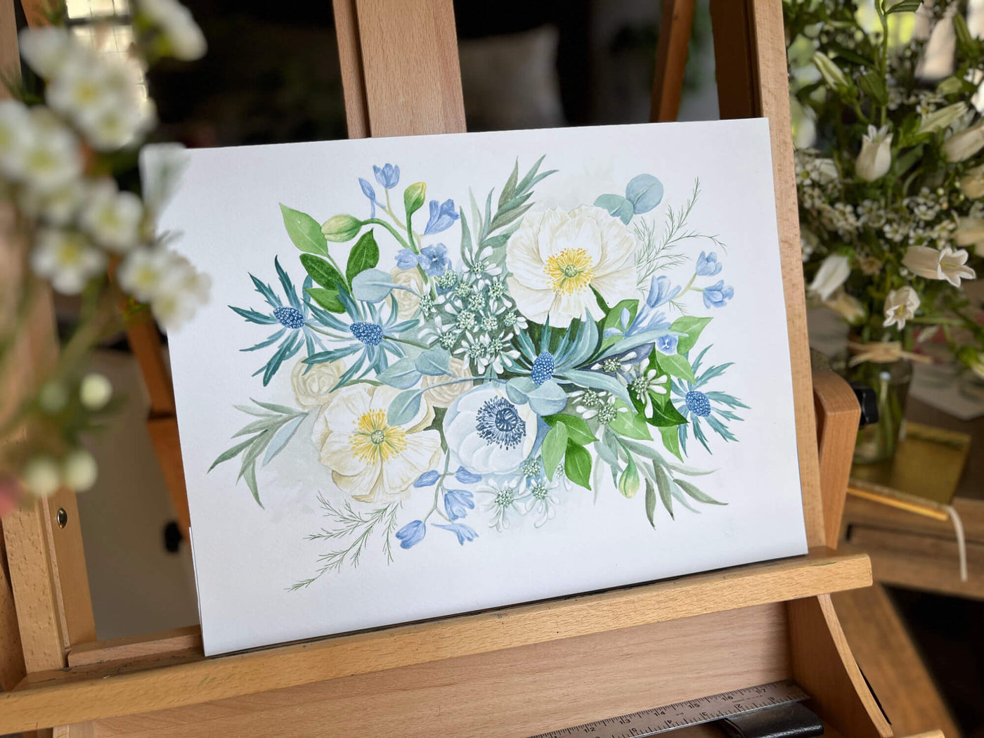 blue wedding bouquet painting on easel with flowers